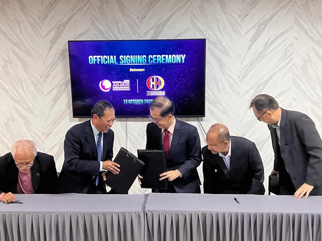 Representatives exchanging documents at the signing ceremony